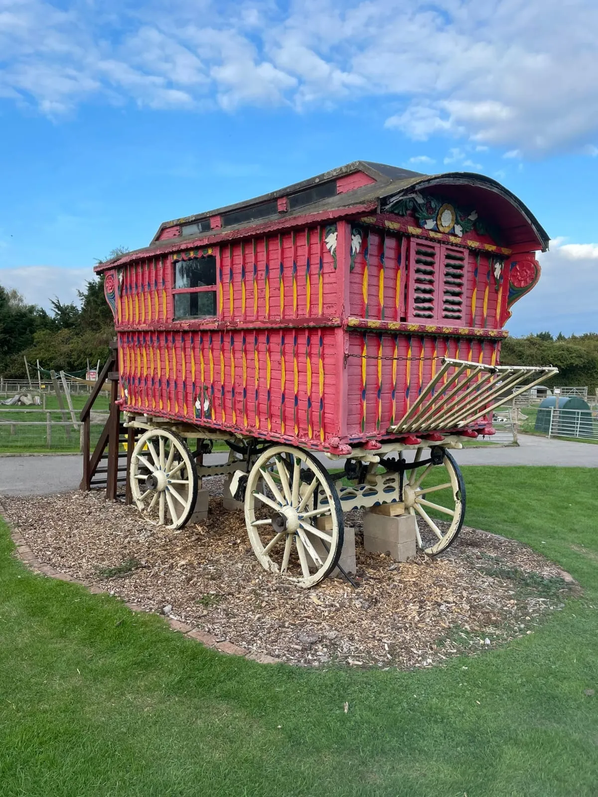 a red wagon sitting on top of a lush green field