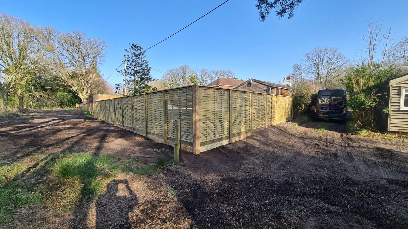 a large wooden fence in the middle of a yard