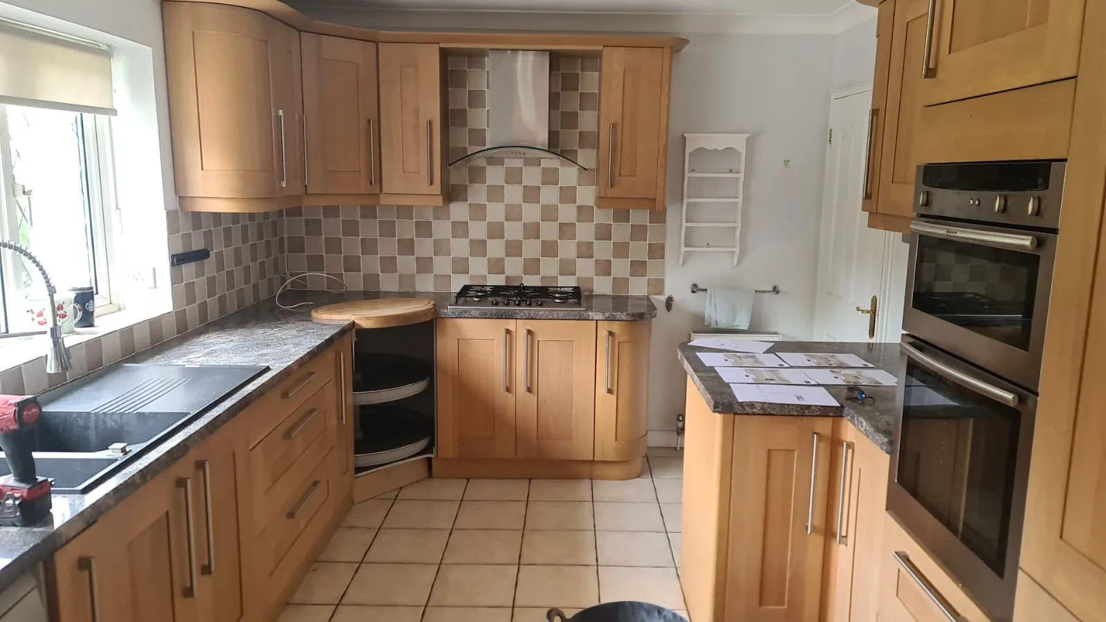 a kitchen with a stove, sink, oven and cabinets