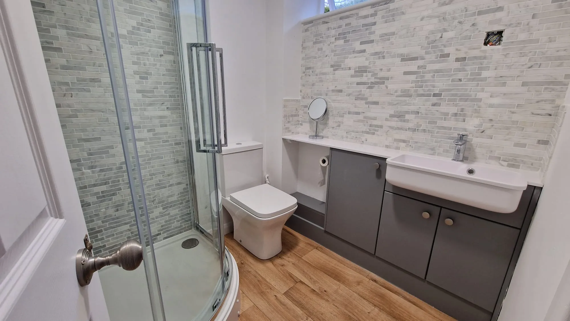 A bathroom with a toilet, sink, and shower.